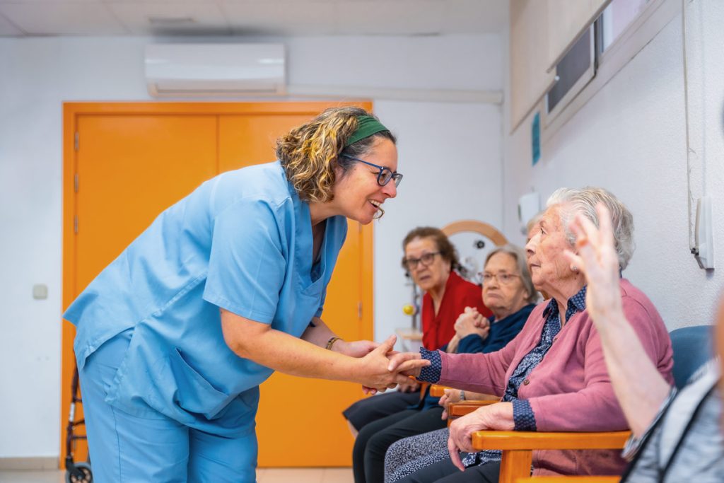 Practitioner shaking a senior lady's hand.