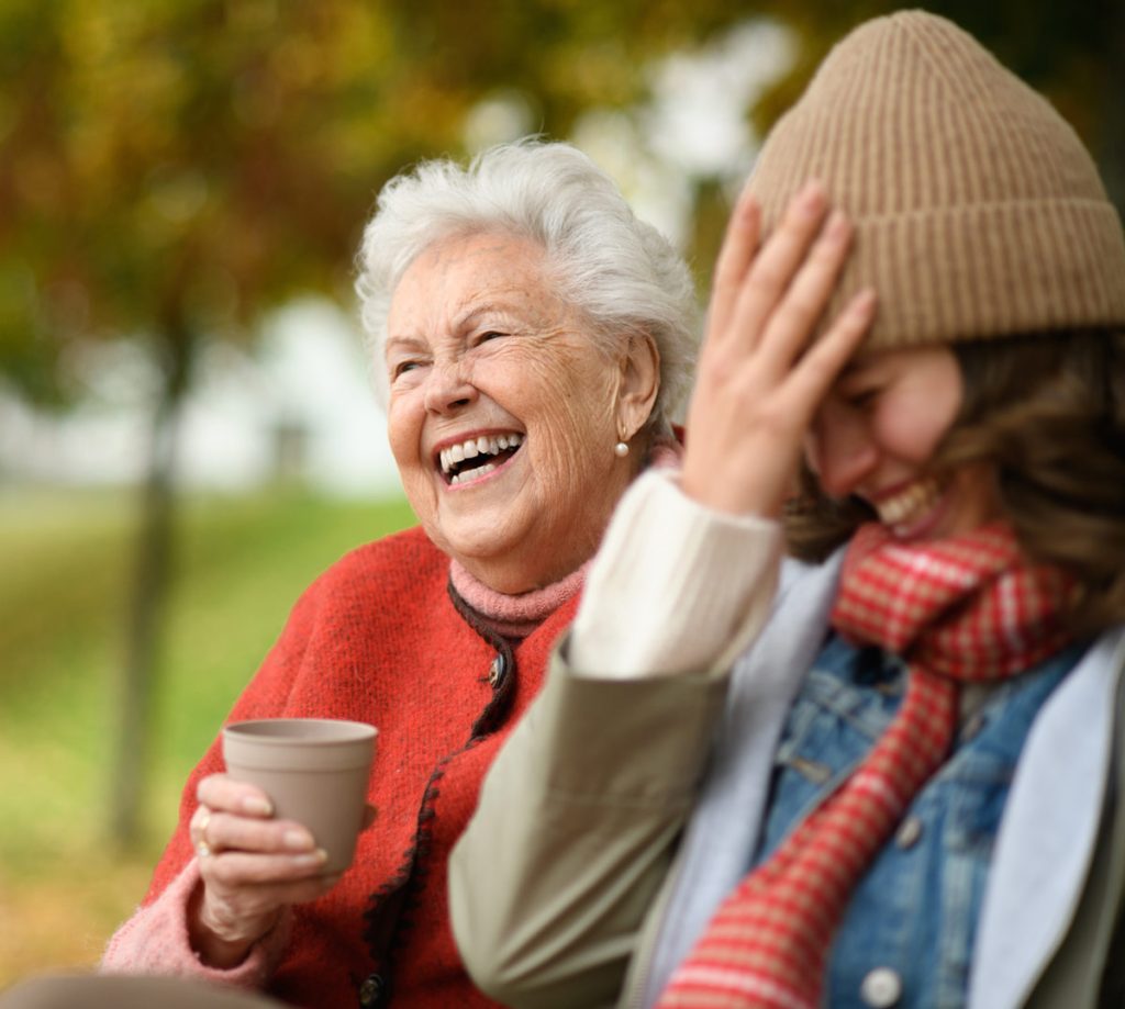 Two women laughing hard out in nature